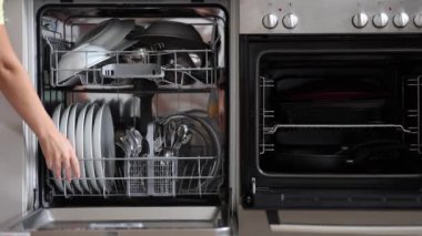 Kadın bulaşıklar temizlendikten sonra bulaşık makinesini açtı. Yavaş çekim videosu. Yüksek kalite 4k görüntü