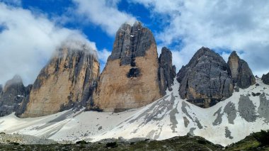 Dolomitler, İtalya - 16 Haziran 2024: Laghi-dei-Piani gölünün kıyısındaki tanınmayan genç çiftin Güney Tyrol 'daki Tre Cime Doğa Koruma Alanındaki güzel manzaraya hayran kalmaları