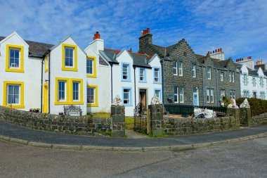 Islay Adası, Inner Hebrides, İskoçya, İngiltere 'deki küçük Port Ellen köyünde mavi bulutlu bir gökyüzüne karşı tipik taş evler sırasının görüntüsü