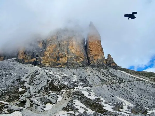 Dairesel yoldan uçan bir kuşa ve bulutlarla örtülü Tre Cime di Lavaredo 'nun ünlü tepelerine bakın. Dolomitler, Güney Tyrol, İtalya