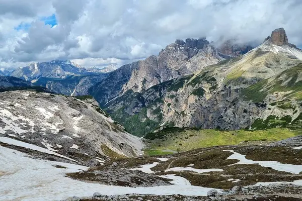 Rengarenk dağları ve Tre Cime di Lavaredo Ulusal Parkı 'ndaki kar kalıntılarıyla dolu pitoresk bir dağ manzarası. Yazın başında bulutlu bir günde. Dolomitler, Güney Tyrol, İtalya