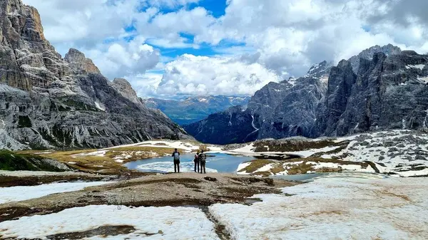 Dolomitler, İtalya - 16 Haziran 2024: Bilinmeyen bir grup turist, Güney Tyrol 'daki ünlü Tre Cime doğa koruma alanının güzel manzarasına hayran kalarak Laghi dei Piani göllerinde durdu.
