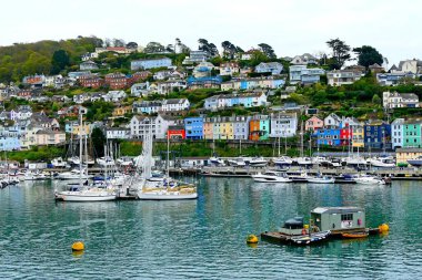 Kingswear, Güney Devon, İngiltere - 25 Nisan 2024: Dart Nehri 'nin doğu kıyısındaki büyüleyici ortaçağ kıyı köyünün panoramik manzaralı evleri ve yelkenli tekneleri