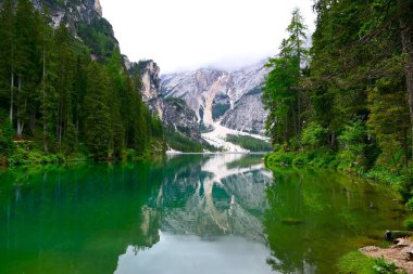 Zümrüt dağ gölü Lago di Braies 'e yansıyan resim gibi manzara, Dolomitler ve efsanelerle gizlenmiş, İtalya