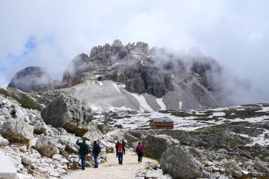 Dolomitler, Güney Tyrol, İtalya - 16 Haziran 2024: Rifugio Lavaredo 'ya giden tanınmamış bir grup turist ünlü Tre Cime di Lavaredo' nun çevresindeki dairesel rota üzerinde
