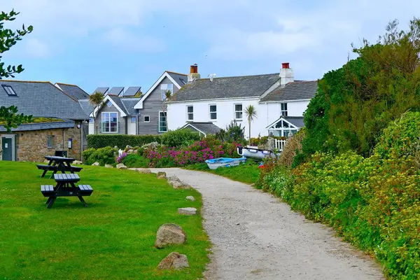Yeşil çimenli bir avludan geçen patika, İngiltere 'nin Scilly Adaları' ndaki St. Mary Adası 'ndaki Hugh Town' da dinlenme ve balıkçı tekneleri için oturma masaları.