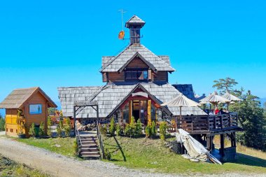 Sırbistan 'ın Zlatibor kenti - 12 Ekim 2023: Altın Gondola Zlatibor teleferiğinin bitiş istasyonu yakınlarında çok katlı kereste çatılı geleneksel Sırp tarzında Konforlu Ziyaretçi Kafesi 