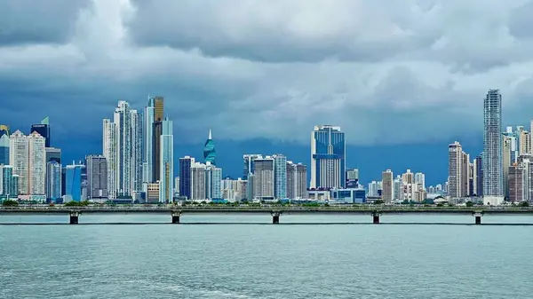 Gelişen ticari şehir Panama City 'nin modern gökdelenlerinin panoramik görüntüsü fırtınalı bir gökyüzüne karşı yoğun bir siluet oluşturur.