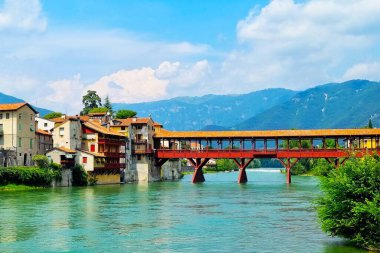 Bassano-del-Grappa, İtalya - 17 Haziran 2024: Dağ nehri üzerindeki antik ahşap köprü Ponte Vecchio 'nun manzarası 