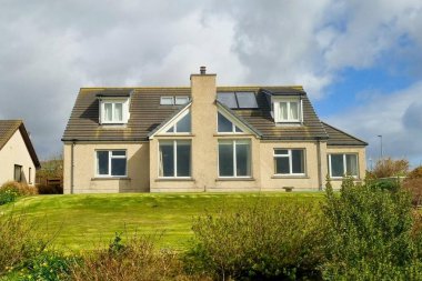 Orkney Adaları 'nın dış cephesinde yatakhanesi ve bacası olan küçük bir köy evi manzarası. 