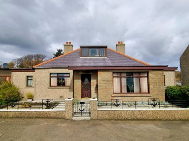 İskoçya 'nın kuzeydoğusundaki ücra Orkney Adaları' ndaki eski tarz bacaları olan küçük taştan bir evin görüntüsü.