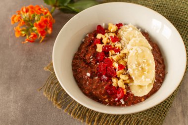 Yulaf ezmesi, kakao, muz, fındık ve kırmızı meyveli sağlıklı bir kahvaltı.