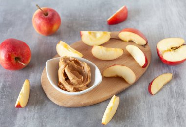 Taze elma ve fıstık ezmesinden yapılmış sağlıklı ve besleyici atıştırmalıklar.