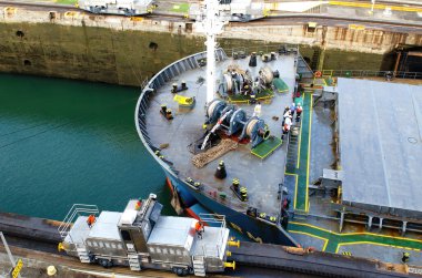 Panama City, Panama - February 20, 2015: Tankship prow detail with crew at work, entering the Canal locks of Miraflores in the Panama Canal, the Canal locks are at each end to lift ships up. clipart