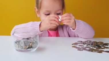 Ekonomik küçük kız çocuğu gelecek ihtiyaçlar için kumbaraya para yatırdı. Tasarruf, bütçe planlaması. 
