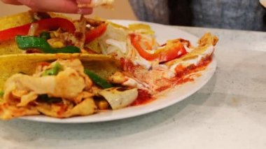Tako, çeşitli sebzeler, et ve lahana turşusu ye. Asya restoranında plastik çatalla. Yüksek kalite 4k görüntü