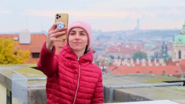 Prag 'daki genç turist kadın internette paylaşmak için cep telefonunun fotoğrafını çekiyor. Yüksek kalite 4k görüntü