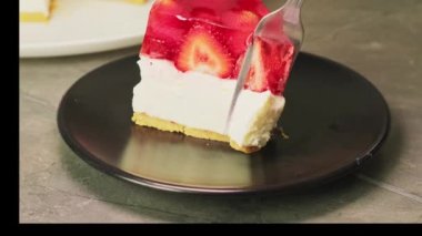 Beyaz tabakta ev yapımı soğuk çilekli cheesecake jöleli tart. Yüksek kaliteli video