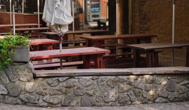 Açık havada boş yaz kahvesi ve ahşap masaları ve sandalyeleri olan restoran terası. Yüksek kalite fotoğraf