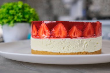Beyaz tabakta ev yapımı soğuk çilekli cheesecake jöleli tart. Yüksek kalite fotoğraf