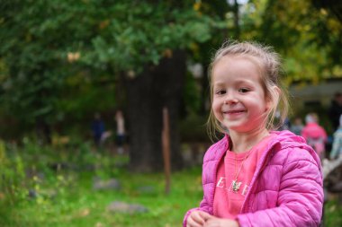 Saçları örgülü küçük bir kızın arkasından dışarıdaki göle bakıyor. Yüksek kalite fotoğraf