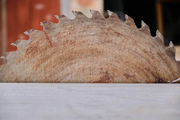 Metal circular saw blade with teeth over the work table. Firewood sawing machine in the household