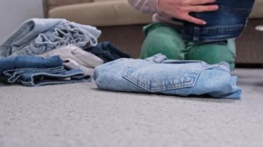 Kadın pantolonları katlayan elleri var. Düzen konseptini bir araya getirmek. Yüksek kalite 4k görüntü