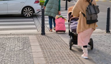 woman with a baby stroller at a pedestrian crosswalk crossing the road. High quality photo