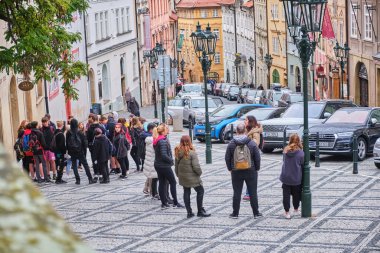 PRAGUE, CZECH REPUBLIC - October 9,2022: Group of tourists are listening to a guide talking in Old Town Square. High quality photo