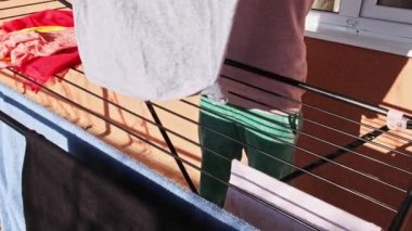 Hands Of A woman Putting Clothes towels On Dryer rack outdoor. High quality 4k footage