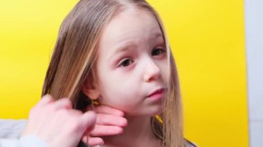 Mother combing daughters wet hair doing little girl hair after shower . High quality 4k footage