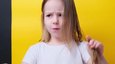 Komik küçük bir kız el sıkışıyor saç kesiminden sonra iki saç örgüsü kesiliyor. Yüksek kalite 4k görüntü