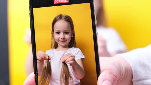 Mała Dziewczynka Pozowanie Fryzurze Dwa Warkocze Dłoniach Śmieszne Uśmiechnięte Żółte — Wideo stockowe