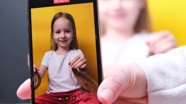 Mała Dziewczynka Pozowanie Fryzurze Dwa Warkocze Dłoniach Śmieszne Uśmiechnięte Żółte — Wideo stockowe