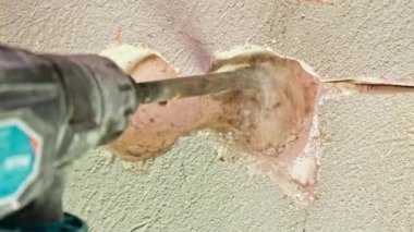 Elektrik prizi deliği elektrikli çekiç matkabı yeni binanın betonunu kırıyor. Tamir işleri, duvarların yıkılması. Yüksek kalite 4k görüntü