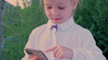 Akıllı telefon kullanarak parmaklarını kaydıran küçük çocuklar. Sosyal ağlarda sohbet eden küçük kız çevrimiçi video bağımlılığı. Yüksek kalite 4k görüntü