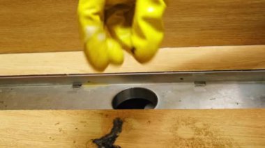 El sarısı lastik eldivenler tıkanmış lavabo tıkanmış banyo tıkanmış saç tıkanıklığını temizliyor. Temizlik ve hijyen. Yüksek kalite 4k görüntü