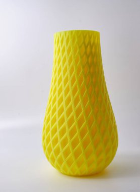 Yellow Art object flower vase home decor printed on 3D printer from melted orange plastic. progressive technology 3D printing recycling. High quality photo clipart