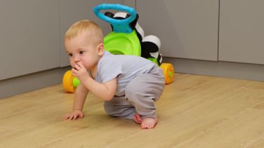 Küçük çocuk yerden kalkar yardım almadan bir kaç adım atar ve elma yerken düşer. Cesaret ve azim. Yüksek kalite 4k görüntü