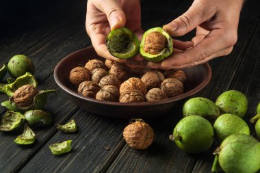 Aşçı mutfakta kullanmak için mutfak masasındaki cevizleri temizler. Cevizli bir şefin yakın çekimi.