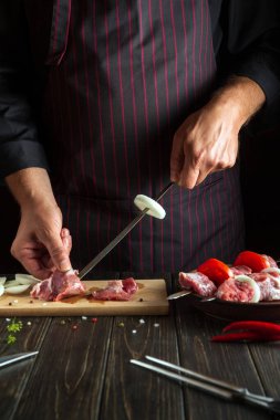 Mutfakta şefin elleriyle taze çiğ etten şiş kebap pişirmek. Asya geleneksel mutfağı