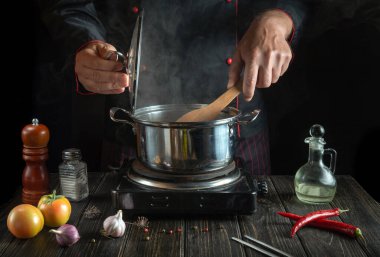 Diyet çorbası aşçının elleriyle sıcak bir tencerede pişirilir. Restoranda öğle yemeği için nefis yemekler..