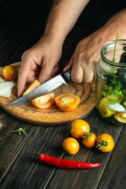 Şef, mutfak kesim tahtasıyla domates kesiyor. Köylü yemeği. Restoran ve otel tarifi.