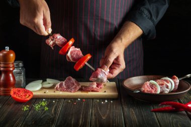 Profesyonel şef taze et dilimlenmiş şiş kebap hazırlıyor. Geleneksel doğu yemeği barbeküsü. Asya mutfağı