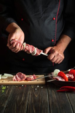Profesyonel şef taze et dilimlenmiş şiş kebap hazırlıyor. Geleneksel doğu yemeği barbeküsü. Asya mutfağı