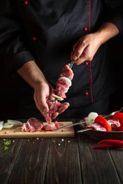 Restoranın mutfağında kuzu kebabıyla hazırlanmış et kebabı şefin ellerinde. Lezzetli bir öğle yemeği fikri