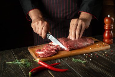 Aşçı pişirmeden ya da ızgara yapmadan önce et doğruyor. Restoranın ya da otelin mutfağında çalışma ortamı