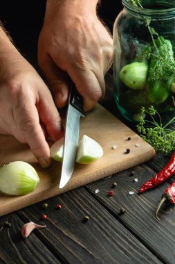 Şef baharat ve salatalık turşusu için taze soğan keser. Mutfak masasında çalışırken aşçıların ellerini yakın plan çek. Reklam için yer