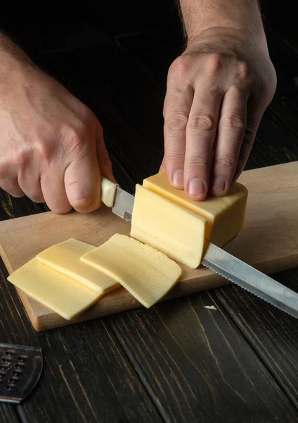 요리사는 손으로 치즈를 조각으로 잘라서 보았습니다 맛있는 — 스톡 사진