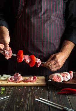 Profesyonel şef mutfakta çiğ kuzu etli şiş kebap hazırlıyor. Asya ulusal mutfağı